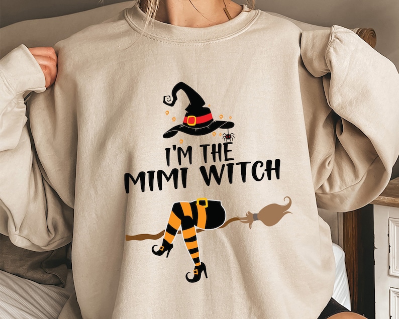May include: A beige sweatshirt with a black and orange witch graphic and the text "I'm the Mimi Witch".