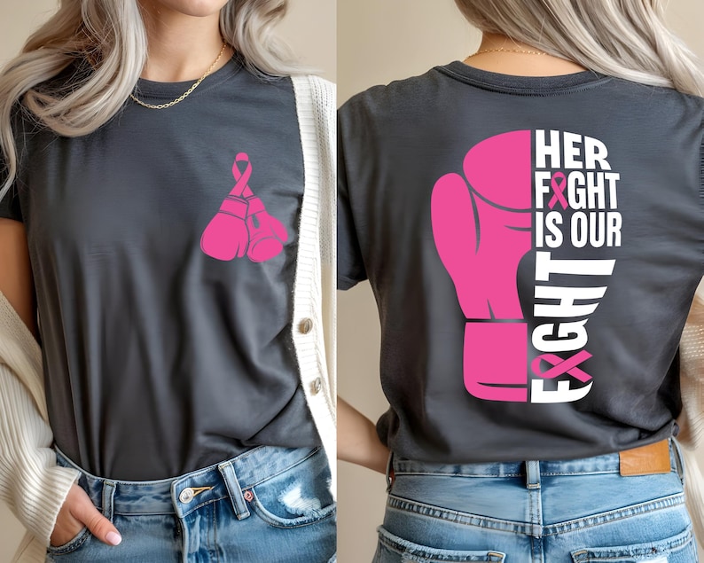 Pode incluir: Camiseta cinza escuro com um design de luva de boxe e fita rosa. A frente apresenta duas luvas e uma fita. A parte de tr&aacute;s exibe uma luva grande com o texto "HER FIGHT IS OUR FIGHT".