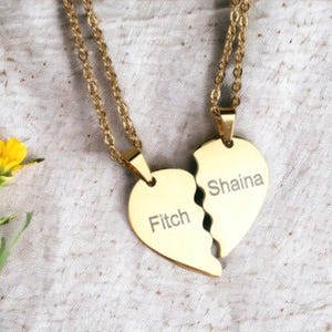 Peut inclure: Deux colliers en or avec des pendentifs en forme de cœur brisé assortis. Les pendentifs sont gravés des noms "Fitch" et "Shaina".