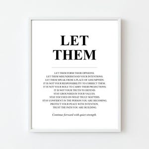 May include: A framed print featuring the words "LET THEM" in bold black lettering. Beneath, a list of affirmations is printed in a smaller font. The print is set within a white frame.