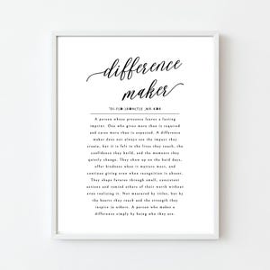 Puede incluir: Impresión enmarcada con las palabras "difference maker" en escritura elegante. Debajo, una definición describe a una persona que deja un impacto duradero. El texto negro sobre fondo blanco está enmarcado en un marco blanco, ideal para la decoración.