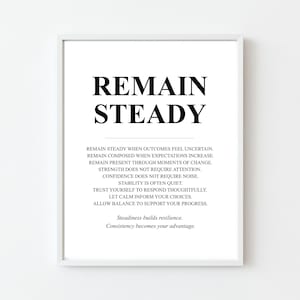 May include: A framed print with the words "REMAIN STEADY" in bold black letters. Below, smaller text provides motivational advice. The print is in a white frame, suitable for home or office decor.
