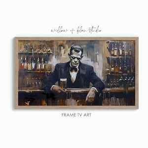 May include: A framed print of a painting showing a monster in a black suit at a bar, holding a pint of beer. The bar is stocked with bottles. The text "willow + bleu studio" and "FRAME TV ART" are visible.