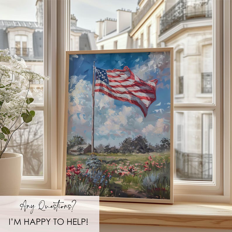 May include: A framed painting of the American flag waving in the wind, set against a backdrop of a blue sky with fluffy clouds. The artwork depicts a field of wildflowers and a small house. The frame is a light wood color. The text "Any Questions? I'M HAPPY TO HELP!" is at the bottom.