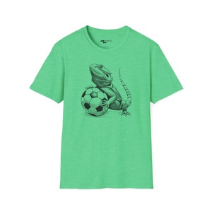 Peut inclure: Un t-shirt vert avec une illustration en noir et blanc d'un dragon barbu tenant un ballon de football.