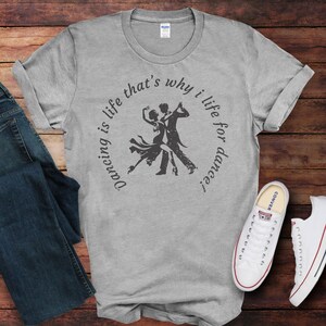 May include: A heather grey t-shirt with a graphic of a couple dancing. The text on the shirt reads "Dancing is life that's why I life for dance."