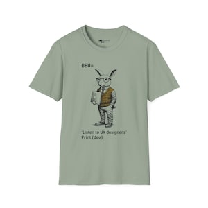 Puede incluir: Una camiseta verde claro con un gráfico de un conejo con gafas y un suéter sosteniendo una computadora portátil. El texto "DEV=" está por encima del conejo y el texto "'Listen to UX designers' Print (dev)" está debajo del conejo.