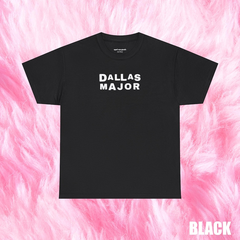 May include: Black t-shirt with the white text "DALLAS MAJOR" centered on the front. The shirt has a crew neck and short sleeves. The words "aged one goods" are printed in small text above the main text. The word "BLACK" is printed in white at the bottom.