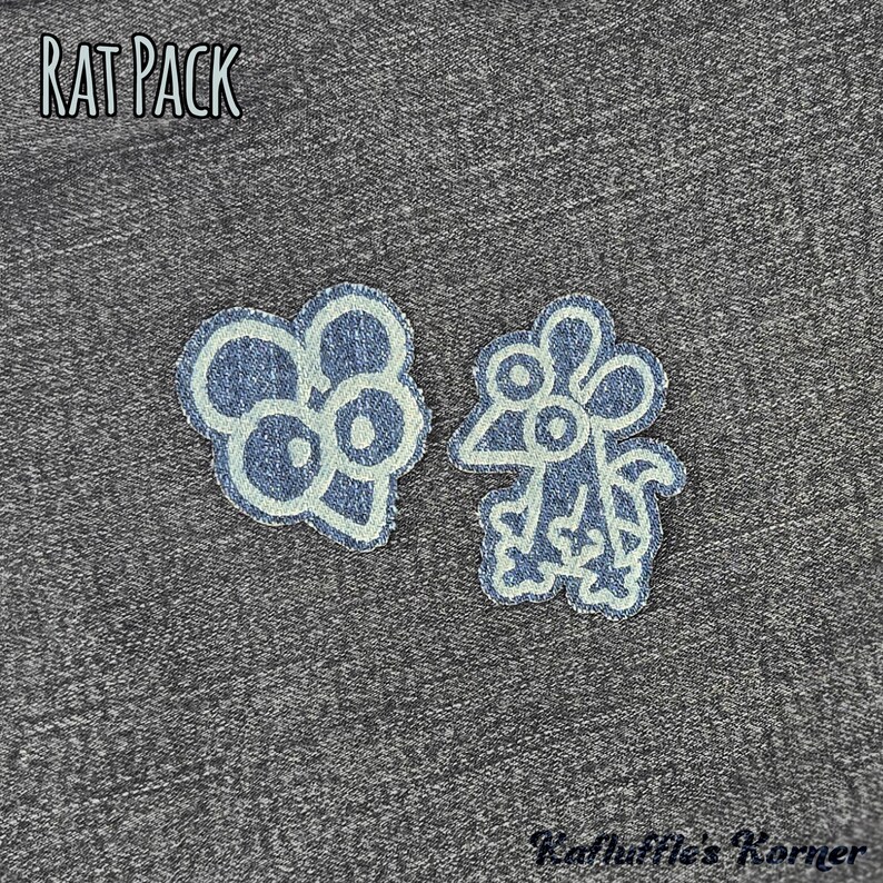 May include: Two denim fabric patches featuring embroidered rat designs with light blue outlines. One patch shows a rat head, the other a full-body rat. The text RAT PACK is at the top left, and Kafluffle's Korner is at the bottom right.