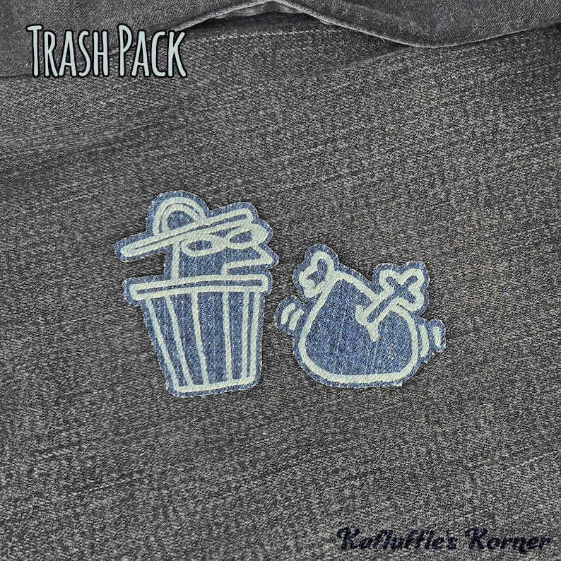 May include: Two denim fabric patches featuring light-coloured embroidered outlines. One patch depicts a trash can with a lid, and the other shows a trash bag with a bone. The text TRASH PACK appears at the top, and Kafluffle's Korner at the bottom.