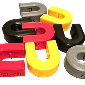 May include: A set of six interlocking plastic rings in red, yellow, black, and gray. Each ring has a small latch and the word "Click" is printed on the red ring.