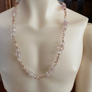 May include: A delicate gold chain necklace with pale pink and clear glass beads.