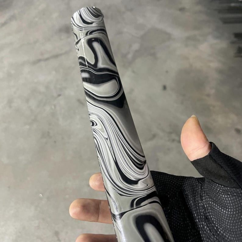 May include: A cylindrical object with a black and white marbled pattern. The object has a smooth, glossy finish.