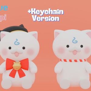 May include: Two white plush cat plushies with blue markings on their foreheads. The cat on the left is wearing a red bow with a gold bell. The cat on the right is wearing a red and white striped collar. The text "Keychain Version" is in the upper right corner of the image.