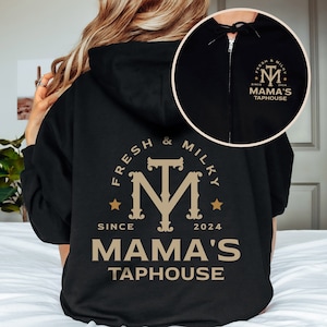 May include: Black hoodie with a gold logo that says "Fresh & Milky" and "Mama's Taphouse" with a stylized "M" and "T" in the centre. The logo also includes the text "Since 2024".