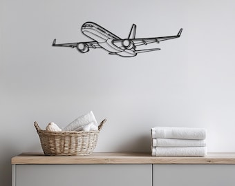 May include: A black metal airplane wall art piece. The airplane is depicted in a line drawing style, with detailed wings, engines, and fuselage. The artwork is mounted on a light gray wall. A wicker basket with towels and a stack of white towels are in the foreground.