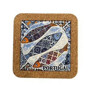 May include: Square cork coaster with three patterned fish in blue, orange, and brown. The fish are set against a blue and white tile design, with the word "PORTUGAL" at the bottom. A decorative item.