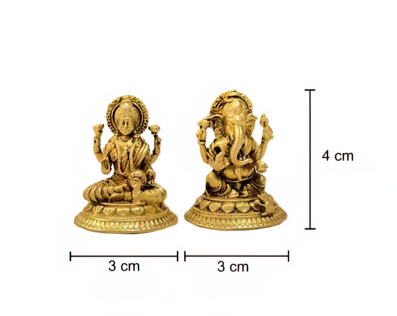 Pode incluir: Duas est&aacute;tuas douradas das divindades hindus, Lakshmi e Ganesha, s&atilde;o exibidas sobre um fundo branco. Lakshmi est&aacute; sentada, e Ganesha &eacute; retratado com uma cabe&ccedil;a de elefante. Cada est&aacute;tua tem 3 cm de largura e 4 cm de altura.