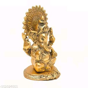 May include: A metallic gold-colored brass figurine of the deity Ganesha, depicted in a seated position with four arms, a prominent trunk, and large ears. The figure is set against a circular, sunburst-style halo and rests on a textured base.