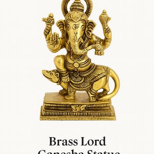 Op de afbeelding: Een messing Lord Ganesha-beeld. Het gouden beeld toont Ganesha zittend op een rat, met ingewikkelde details. Het beeld staat op een rechthoekige basis, en de tekst "Brass Lord Ganesha Statue" staat eronder.
