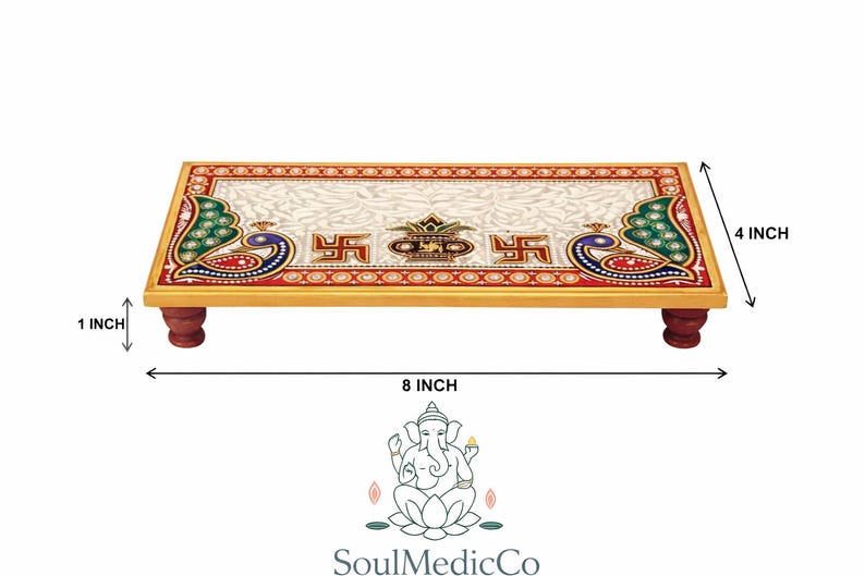 Pu&ograve; includere: Piattaforma rettangolare in legno con piano in marmo bianco, decorata con pavoni e simboli religiosi. La piattaforma &egrave; lunga 20 cm, larga 10 cm e alta 2,5 cm, sostenuta da quattro piccole gambe rosso scuro. Il design incorpora accenti rossi, verdi e dorati.