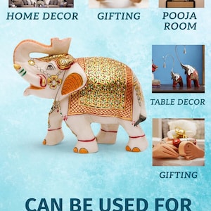 Puede incluir: Figurilla de elefante de color marfil con detalles dorados y naranjas. El elefante tiene una manta decorativa con un patr&oacute;n dorado y verde. La imagen incluye texto: "Home Decor", "Gifting", "Pooja Room", "Table Decor" y "Can Be Used For".
