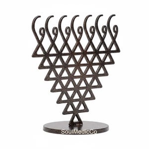 May include: A bronze-colored metal sculpture featuring a triangular design composed of triangles and curved accents. The sculpture is mounted on a circular base. The text "SoulMedicCo" is visible on the base.