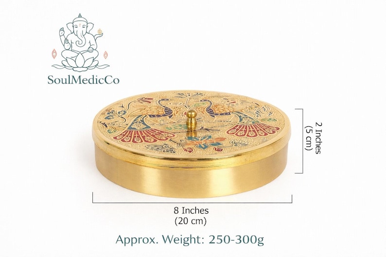 May include: A round, gold-colored container with a lid featuring a peacock design. The container is 8 inches (20 cm) in diameter and 2 inches (5 cm) high. The approximate weight is 250-300g. The SoulMedicCo logo is in the upper left corner.