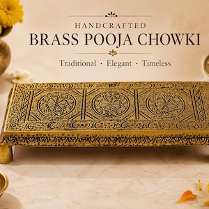 Op de afbeelding: Een handgemaakte messing Pooja Chowki, een traditioneel en elegant stuk. Het rechthoekige platform heeft ingewikkelde zwarte en gouden patronen, met drie cirkelvormige ontwerpen. De tekst luidt "Traditioneel, Elegant, Tijdloos."