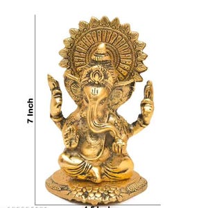 May include: A gold-colored brass statue of the deity Ganesha in a seated position, featuring an ornate circular halo, trunk curved to the left, and raised hands. The statue measures 7 inches in height and 4.5 inches in width as indicated.