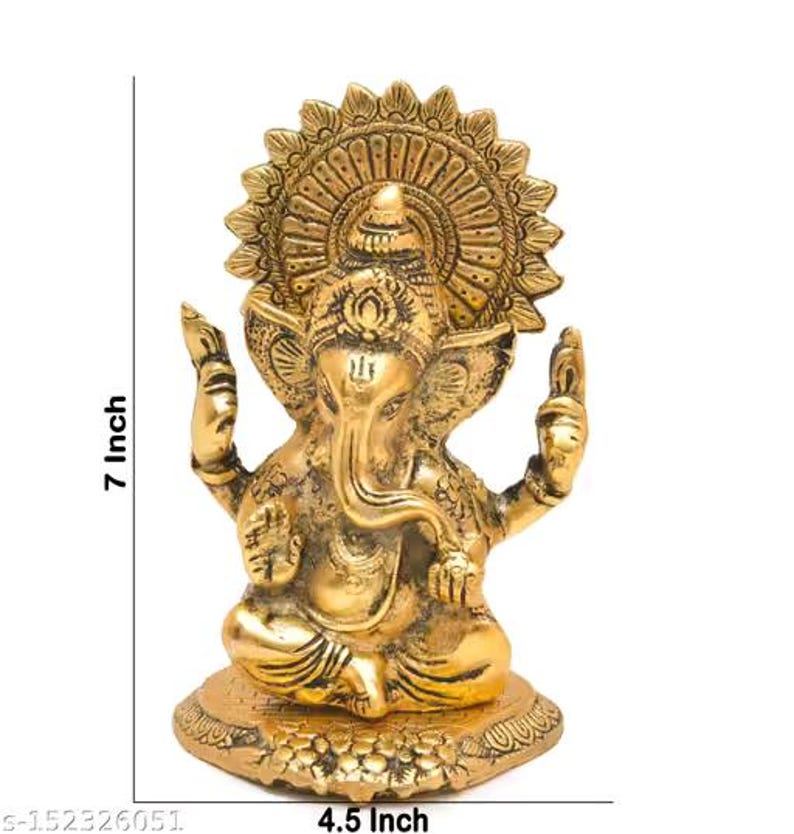 May include: A gold-colored brass statue of the deity Ganesha in a seated position, featuring an ornate circular halo, trunk curved to the left, and raised hands. The statue measures 7 inches in height and 4.5 inches in width as indicated.