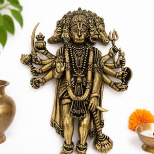May include: A detailed bronze-coloured statue of a multi-faced deity with multiple arms, holding various objects. The statue is adorned with intricate jewellery and clothing. The background is white, with a few decorative elements.