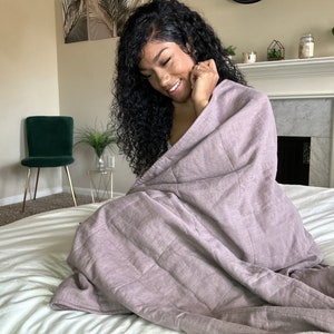 women covered in linen weighted blanket