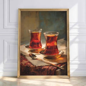 Puede incluir: Pintura enmarcada que representa dos vasos de té en forma de tulipán sobre platillos. Una cuchara y un cuchillo están sobre la mesa. La pintura tiene un marco dorado y está colocada contra una pared blanca.