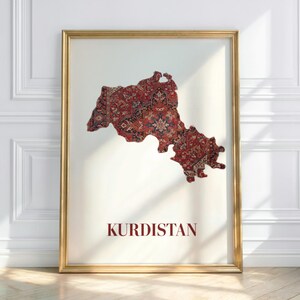 Könnte beinhalten: Ein gerahmter Druck mit einer Karte von Kurdistan, gestaltet mit einem traditionellen Teppichmuster. Die Karte ist überwiegend rot mit detaillierten Mustern, vor einem weißen Hintergrund. Das Wort "KURDISTAN" ist dunkelrot darunter gedruckt. Der Rahmen ist goldfarben.