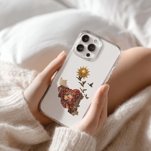 Könnte beinhalten: Transparente Handyhülle mit floralem Kartendesign, Sonne und fliegenden Vögeln. Die Hülle hat einen transparenten Rand und ein dekoratives Design auf der Rückseite. Für ein Smartphone konzipiert.