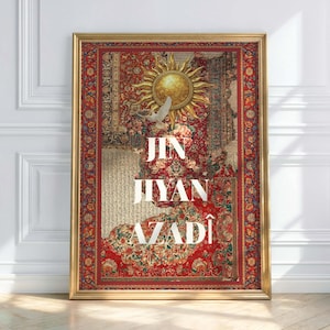 May include: Framed art print featuring a detailed, colorful rug design with a sun and dove motif. The text "JIN JIYAZ AZADÎ" is displayed in white. The frame is gold, and the artwork is displayed against a white wall.