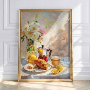 Könnte beinhalten: Gerahmtes Stillleben-Gemälde, das eine Frühstücksszene darstellt. Ein Croissant und eine Brotscheibe liegen auf einem Teller mit einem Messer. Ein Glas Kaffee, eine Zitrone und eine Kaffeemaschine sind ebenfalls zu sehen. Eine Vase mit weißen und rosa Blumen vervollständigt die Szene.