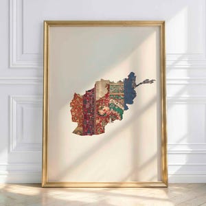 Może przedstawiać: Oprawiona grafika przedstawiająca mapę Afganistanu, złożona z różnych kawałków tkaniny we wzory. Grafika jest oprawiona w złotą ramę i wisi na białej ścianie. Kawałki tkaniny zawierają czerwone, zielone i niebieskie wzory.