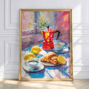 Könnte beinhalten: Gerahmtes Gemälde einer Frühstücksszene. Eine rote Kaffeemaschine steht auf einer blau-weißen Tischdecke, zusammen mit einem Croissant, Zitronen und zwei Tassen Kaffee. Das Gemälde hat einen goldenen Rahmen und steht vor einer weißen Wand.