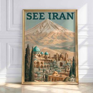 May include: A framed travel poster featuring the text SEE IRAN in dark green capital letters. The illustration depicts a snow-capped mountain peak rising above a desert landscape with traditional architecture, turquoise domes, and tall cypress trees.