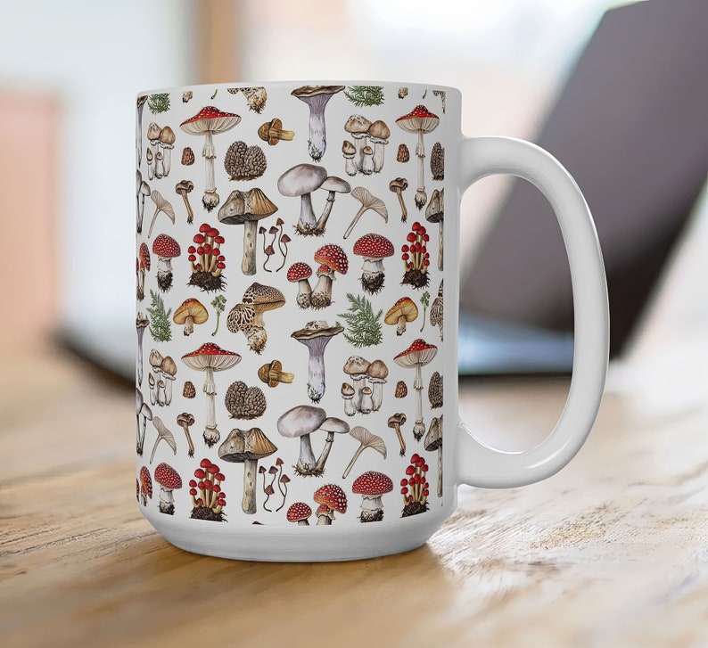 May include: White ceramic mug with a colorful mushroom pattern. The mug has a large handle and is filled with a variety of mushrooms in different colors and shapes.