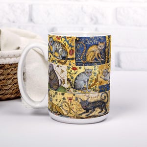 May include: White ceramic mug with a colorful design of cats in a medieval style. The mug has a large handle and is decorated with a repeating pattern of cats in different poses.