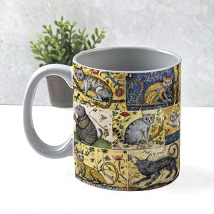 May include: A gray ceramic mug with a handle features a colorful design of cats in a medieval style. The cats are depicted in various poses and are surrounded by intricate floral patterns. The mug is a great gift for cat lovers.