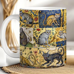May include: A white ceramic mug with a colorful design featuring multiple cats in a medieval style. The cats are depicted in various poses and surrounded by intricate floral patterns.