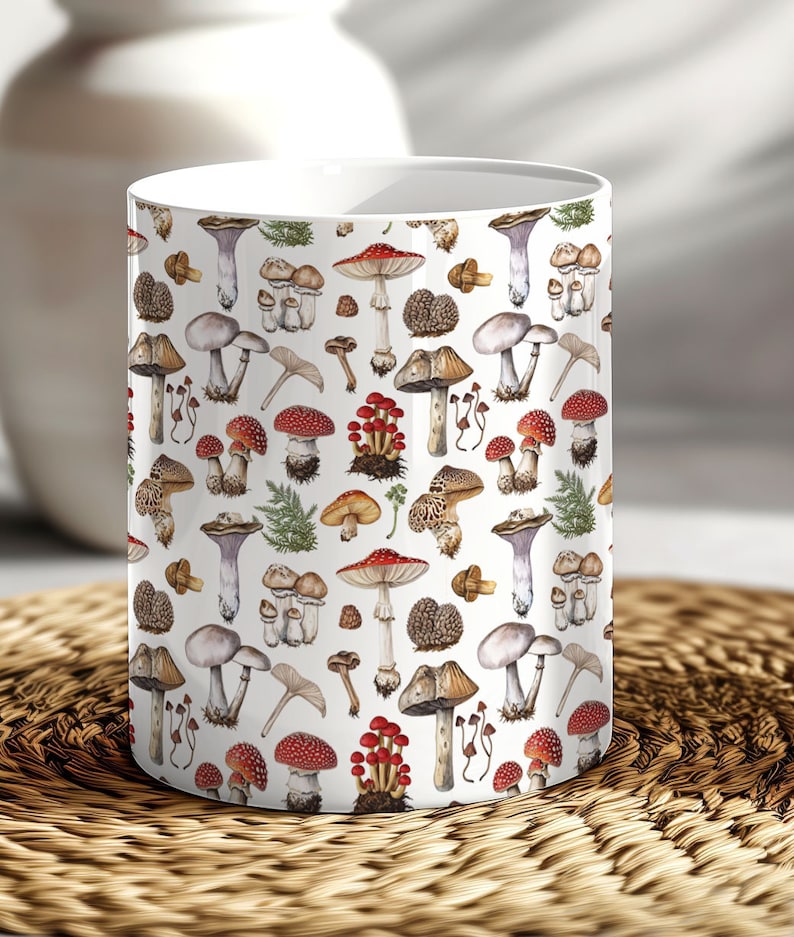 May include: White ceramic mug with a pattern of various types of mushrooms in shades of red, brown, white, and purple. The mushrooms are illustrated in a vintage style.