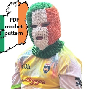 Puede incluir: Un pasamontañas de ganchillo con los colores de la bandera irlandesa: verde, blanco y naranja. El pasamontañas cubre la cabeza y el cuello, con aberturas para los ojos y la boca. La imagen también incluye el texto "PDF crochet pattern" y un contorno de Irlanda.