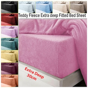 Puede incluir: Una sábana bajera ajustable rosa de forro polar de peluche extra profunda, que se muestra en una cama. La sábana tiene una textura suave y afelpada. El texto "Extra Deep 30cm" es visible. Se muestran opciones de color adicionales en la esquina superior izquierda.