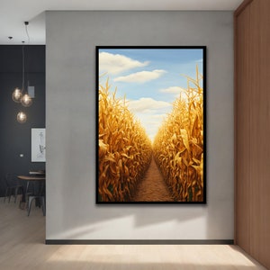 Puede incluir: Obra de arte enmarcada que representa un laberinto de maíz bajo un cielo azul con nubes blancas. Las altas y doradas mazorcas de maíz bordean un estrecho sendero de tierra, creando una sensación de profundidad. La obra está colgada en una pared gris.
