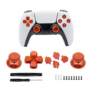 May include: White and orange gaming controller with replacement parts. The controller has a white body with orange buttons and accents. Additional orange thumbsticks, directional pad, and buttons are included, along with tools and screws.